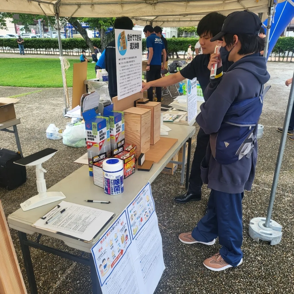 簡易な方法で家具を壁に固定する方法を、来場者に解説している様子